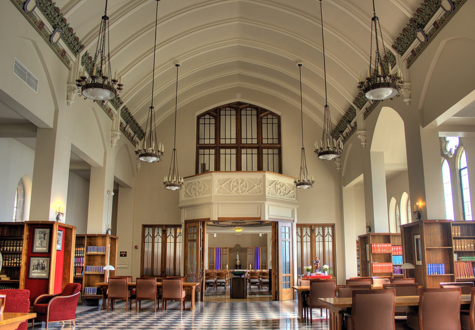 A vaulted library reading room with hanging lanterns