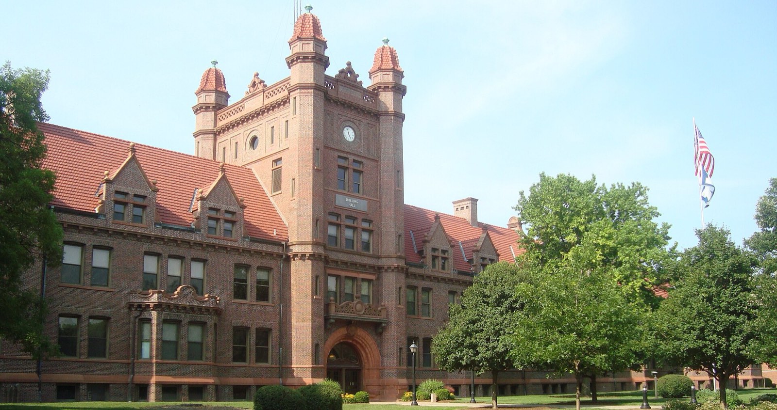 A red-brick college hall with turreted towers
